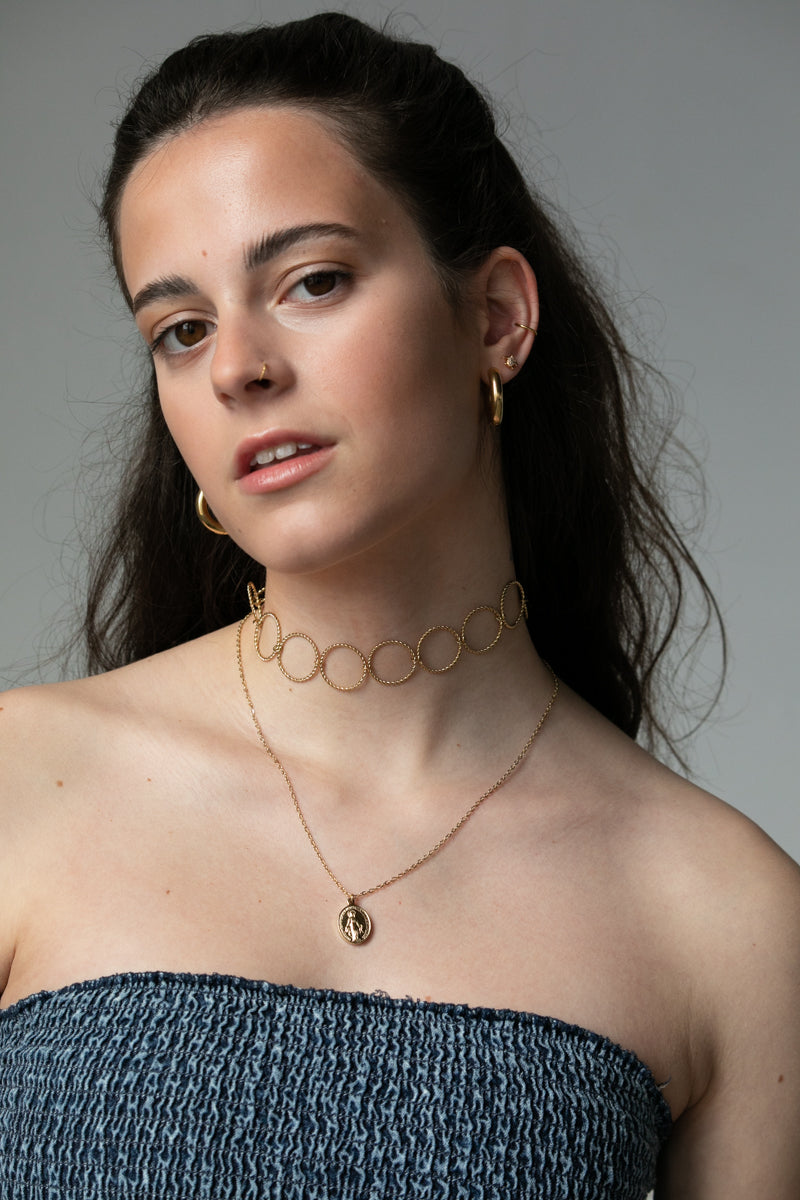 Descubre la elegancia del Collar Virgen. Disponible en color oro y plata, este collar de acero inoxidable es resistente al agua y al sudor, e hipoalergénico.