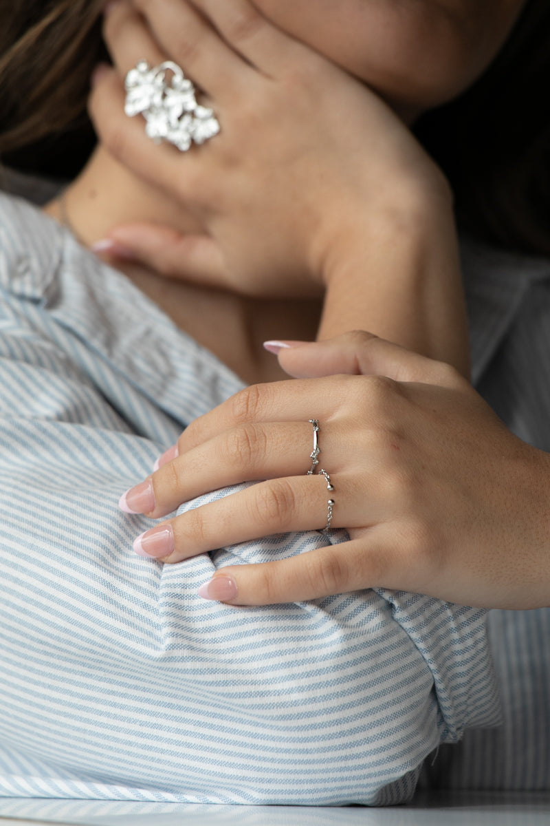 Anillo fino con circonitas incrustadas. Disponible en color plata y resistente al agua.