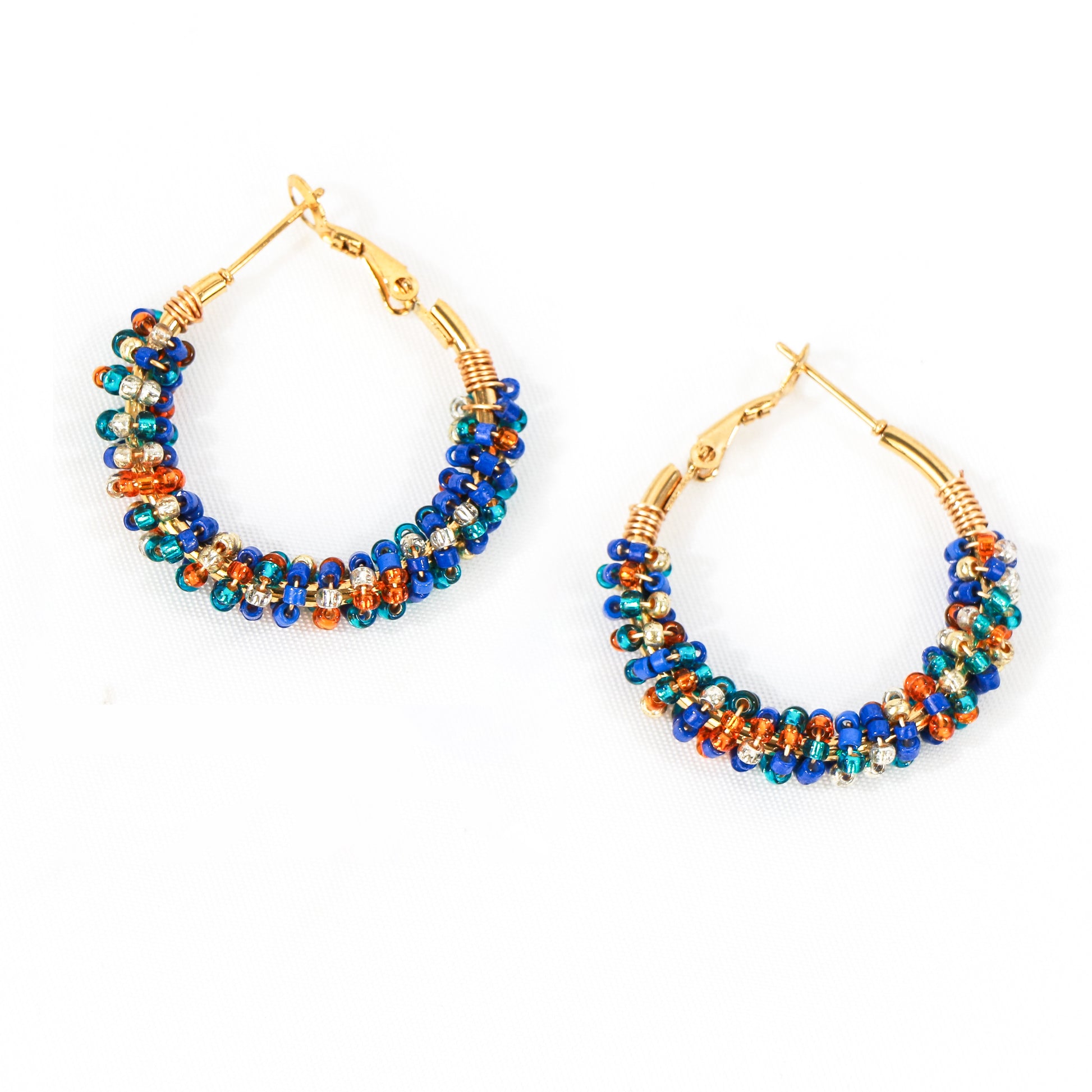 Aros de cierre catalán con detalles acrílicos en tonos azules y anaranjados. Diámetro de 35 mm y de acero inoxidable, perfectos para darle un toque de color a tu look diario.